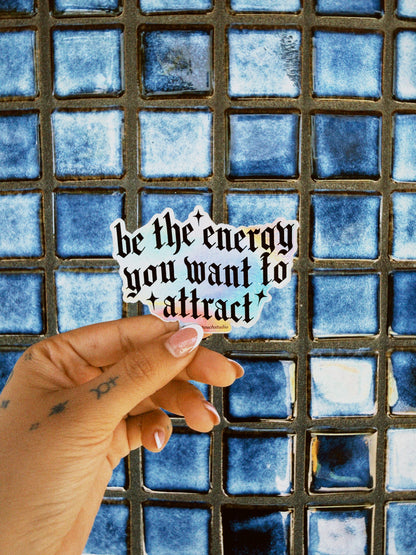 Hand holding a sticker with text against a blue tiled background