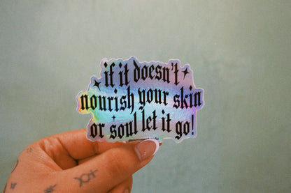 Holographic sticker with motivational text held by a hand against a plain background