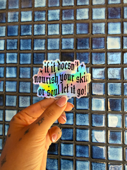 Hand holding a colorful sticker with text against a blue tiled background