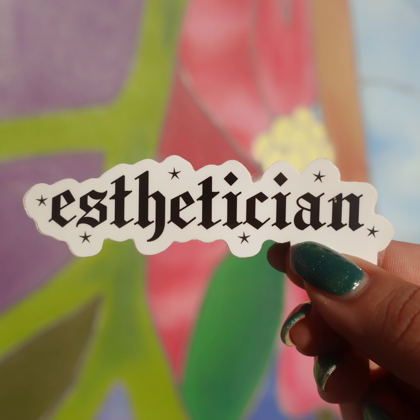 Hand holding a 'esthetician' sticker with colorful background