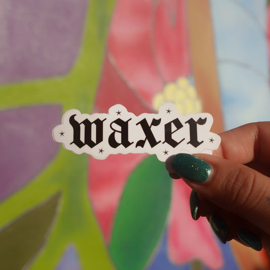 Hand holding a 'waxer' sticker against a colorful floral background